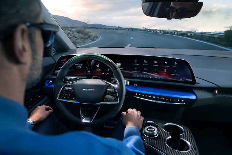 Front View of the 2026 OPTIQ-V Driving Through the Dusk Utilizing its Headlights | Bomnin Cadillac Nanuet in Nanuet NY