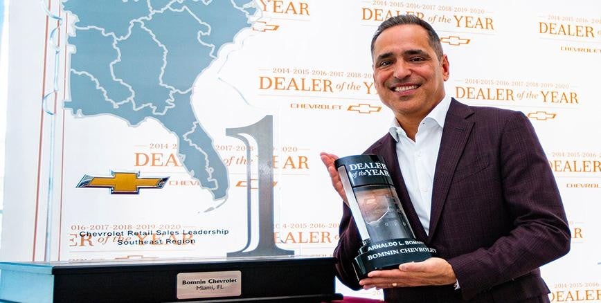 Arnaldo Bomnin holding an award